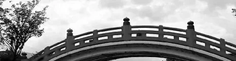 A small, curved bridge in traditional Japanese Shinto architecture.